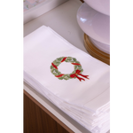 White tea towel with green holly wreath with red ribbon 