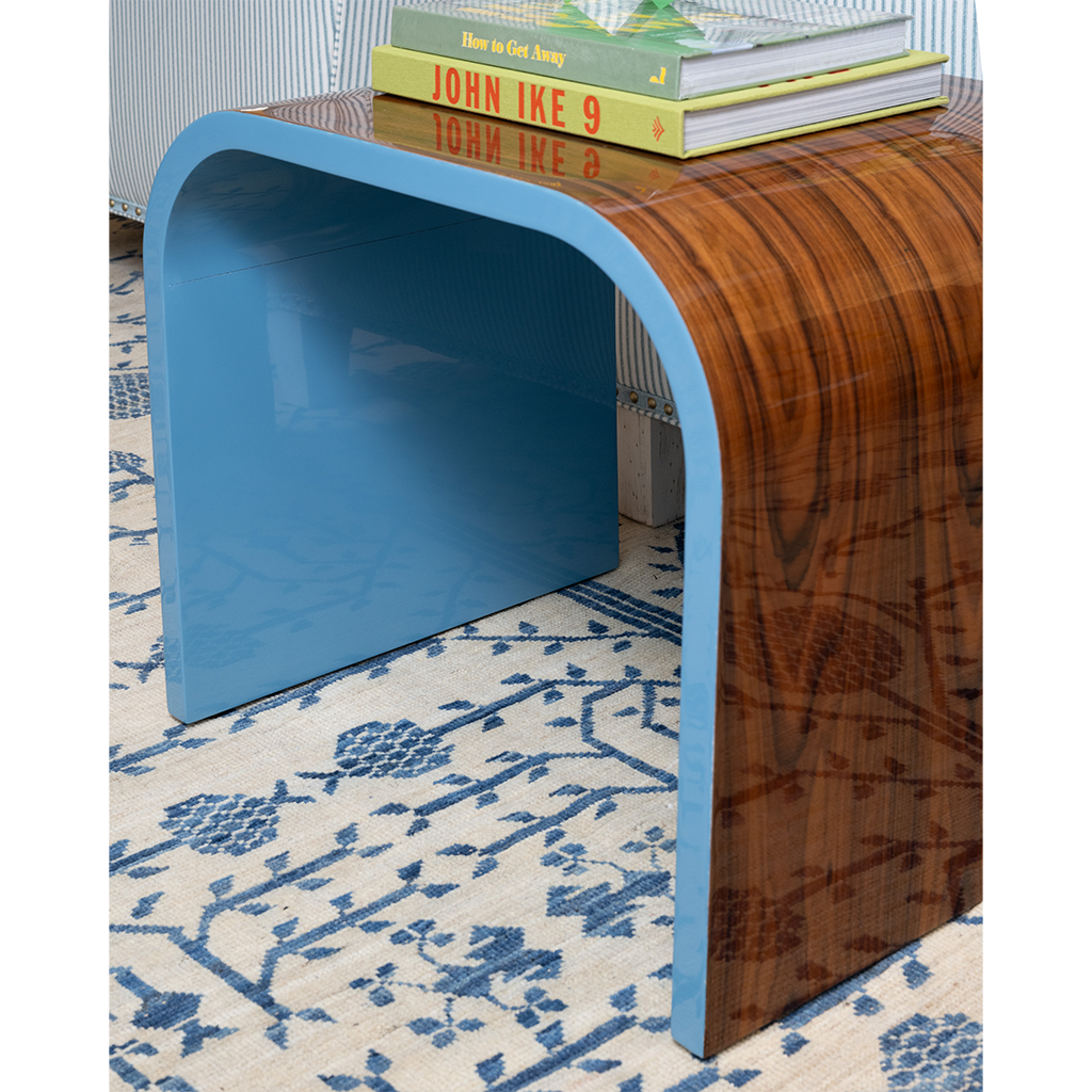 Wooden side table with blue frame on a patterned rug