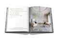 Image of two pages within book. Page on left has quote, and page on right shows a formal living room with an Italian chandelier