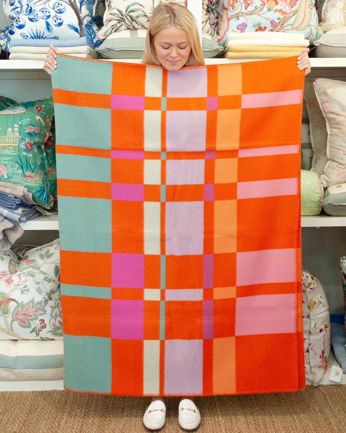 Model holding Tangerine Geometric Blanket