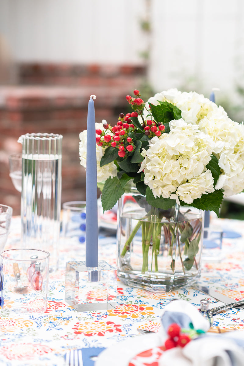 Square Crystal Block Candlestick Holder with blue candle, on table setting next to floral arrangement