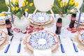 Hydra Salad Plate in Cobalt paired with dinner plate, placemat, flatware and glassware on top of tablecloth