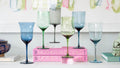 an assortment of wine glasses in different colors on pink "mother and child" book