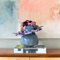 Opaque Blue Rounded Vase in Large with flowers displayed on top of coffee table book