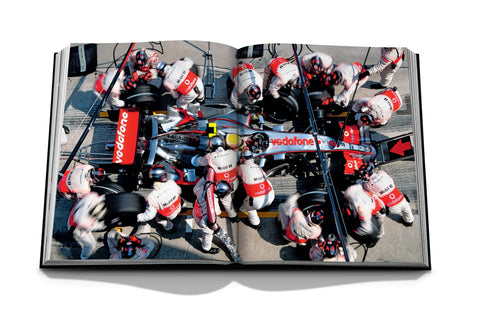 Formula 1: The Impossible Collection Book open showing team tending to Formula 1 car