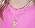 photo of golden rays charm layered with other necklaces