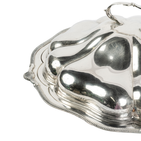 Up close shot of the silver tray with ridged edges, a dome lid with handle. 