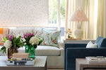 cozy corner featuring rattan box on coffee table next to floral vases and calligraphy brush