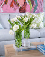 tall, cylindrical green glass vases with white flowers 