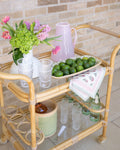 bamboo bar cart decorated with limes and pink pitcher