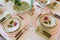 Angled view of Italiano Bloom Deep Plate in Pink with tablescape display