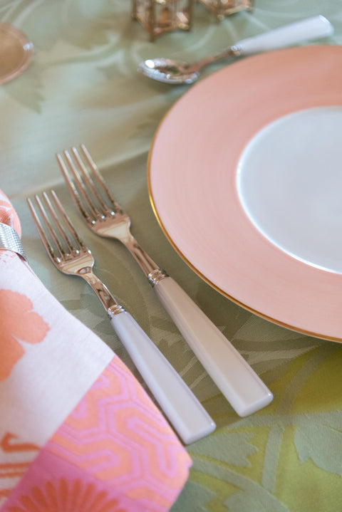 Sabre Paris Icone Flatware in White displayed with napkin and dinner plate on top of tablecloth
