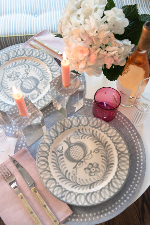 Pomegranate Tree Dinner Plate, Soft Grey, on grey place mat, with acrylic candle holders, and horn flatware