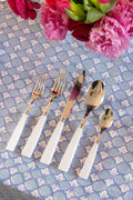 Full set of Sabre Paris Icone Flatware in White on top of tablecloth