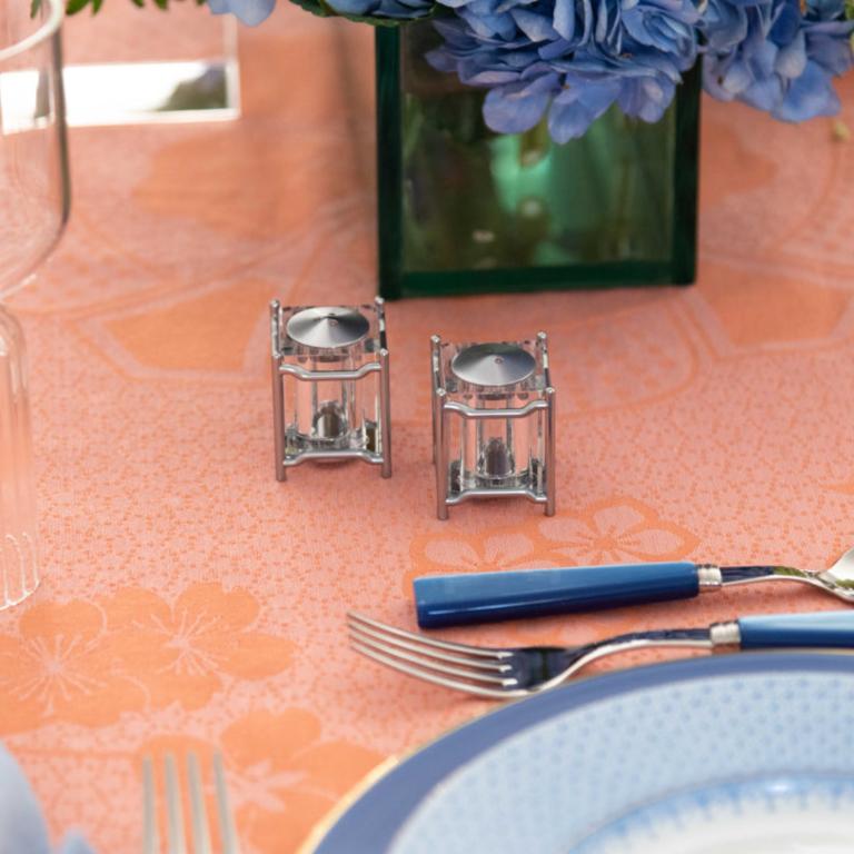 Close up view of L'Objet New York Diner Salt & Pepper Set in Platinum with tablescape display on top of tablecloth