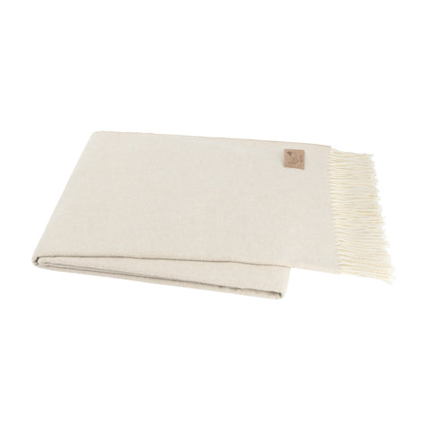 A folded light beige throw blanket with fringe