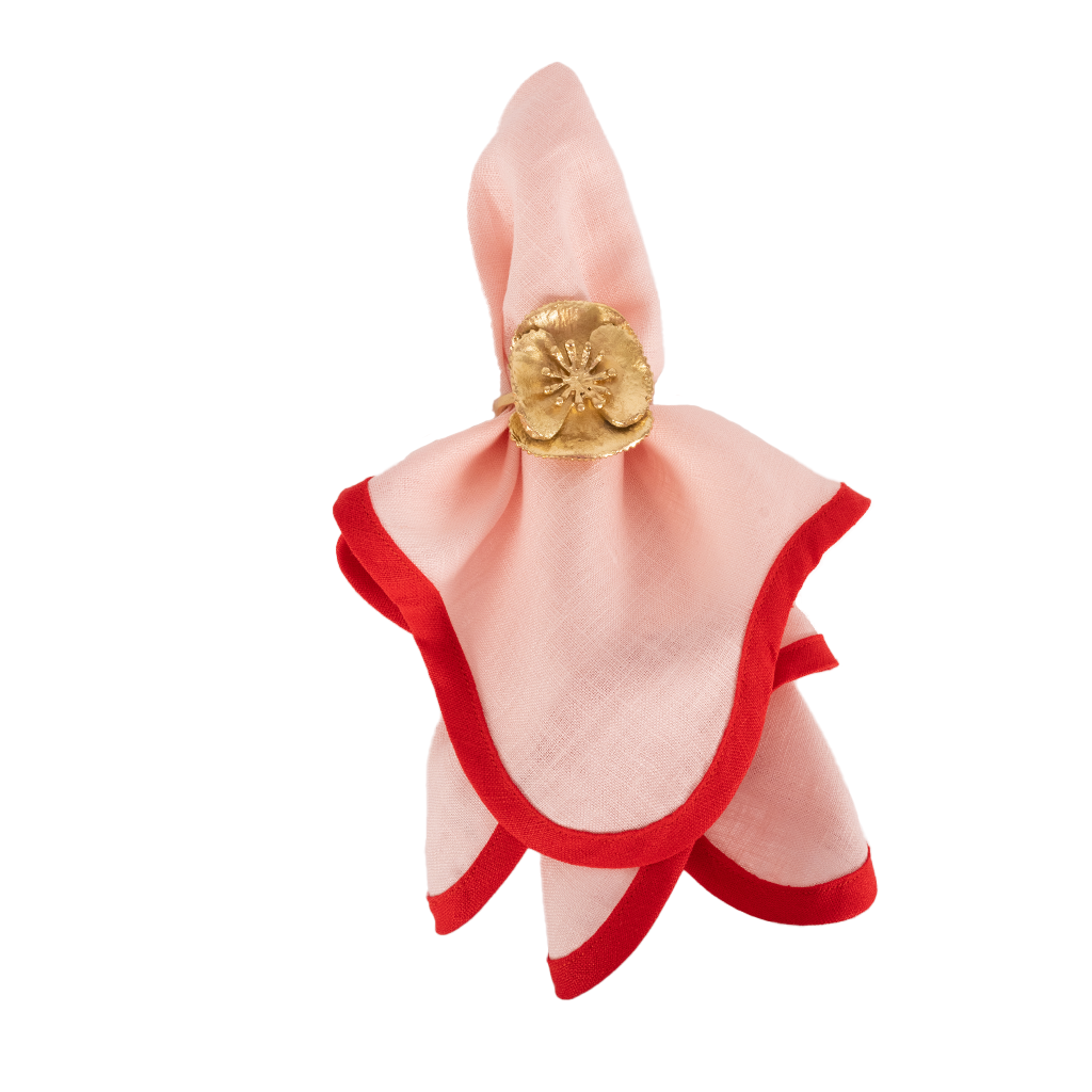 Pink linen napkin with red scalloped piping with gold flower napkin ring