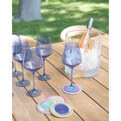 Bubble champagne bucket with a bottle of wine inside styled with cobalt estelle wine glasses and beaded coasters