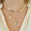 Small Round Locket on model with wishbone charm and gold chain necklace