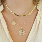 Small Round Locket on model with wishbone charm and gold chain necklace