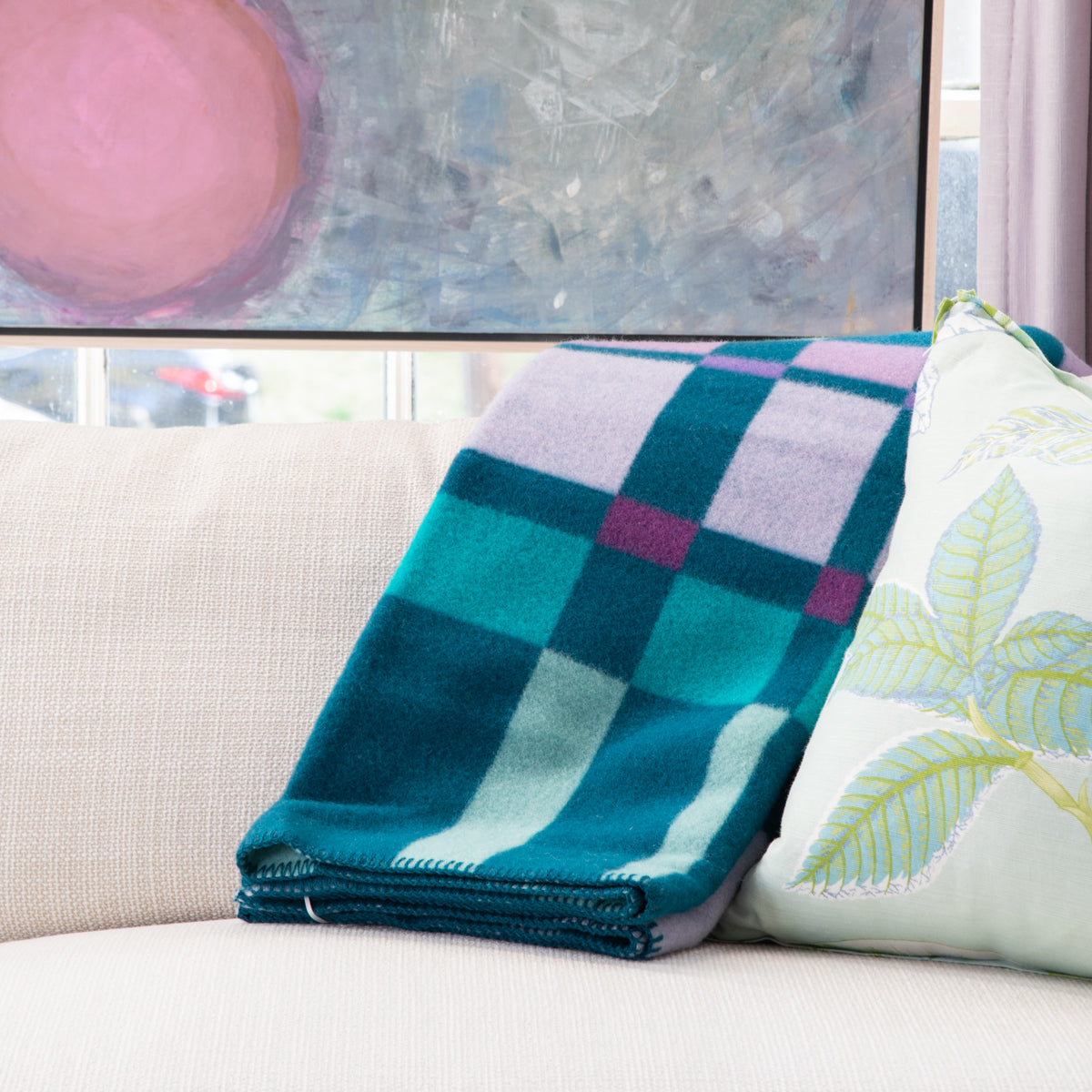 Teal Geometric Blanket thrown over sofa next to pillow