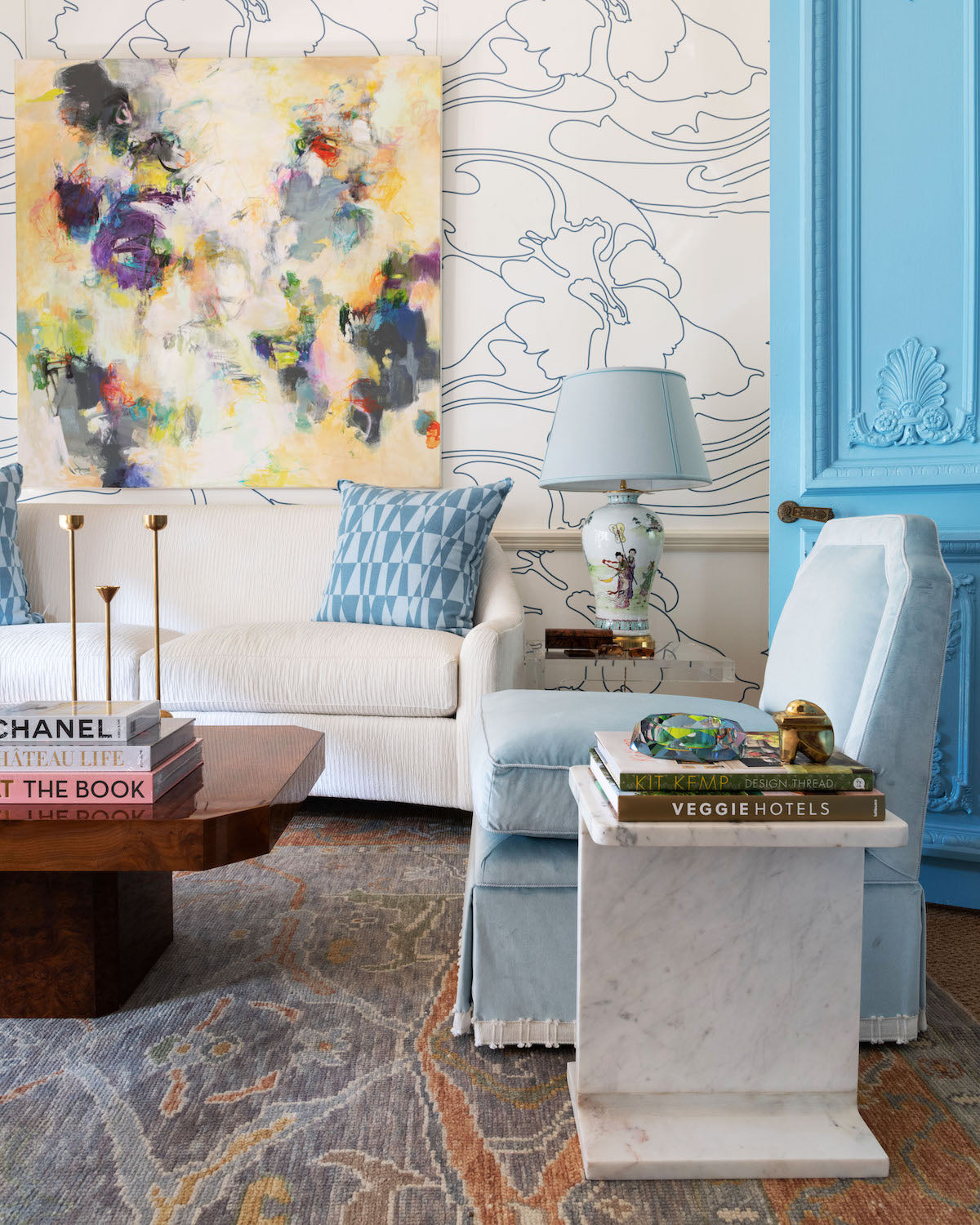 Solstice Side Table styled in room next to blue chair, with books on top