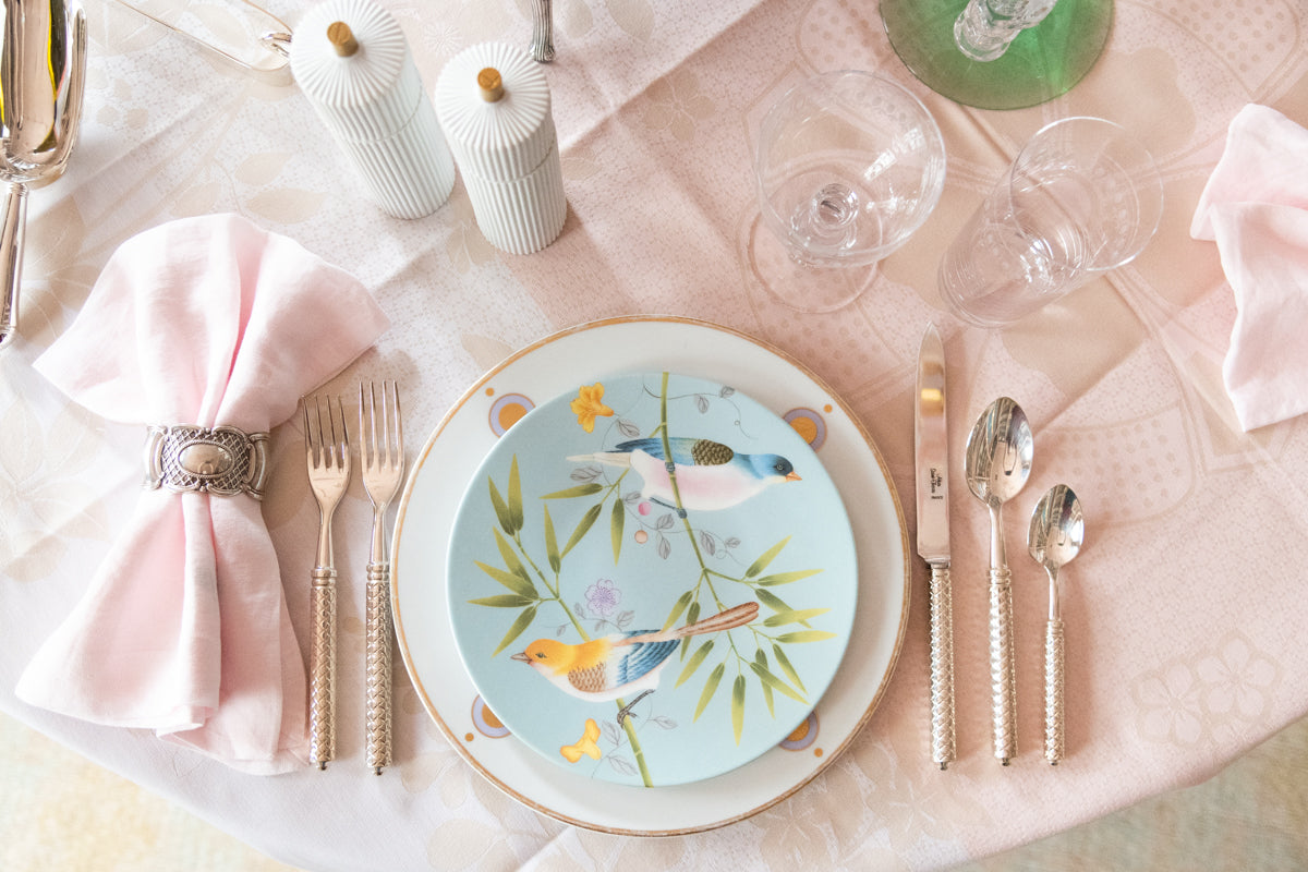 Raynaud Paradis Turquoise Dessert Plate in Two Birds pattern paired with dinner plate, flatware, glassware and napkin on top of tablecloth