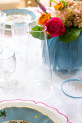 Three Tiered White Embellishment Carafe styled on table next to floral arrangement 